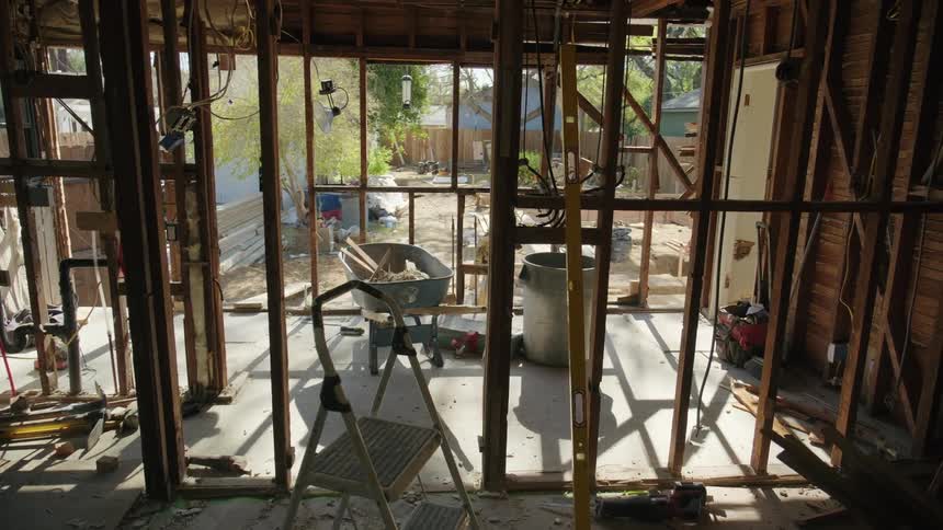 Unfinished and partially dismantled structure reveals the skeleton of a building amidst the rubble
