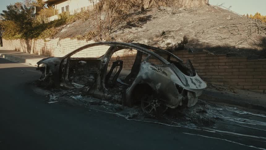 A clip of a ruined car in a community