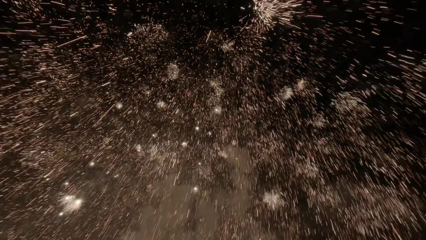 Sparks fall from the fireworks exploding in the night sky
