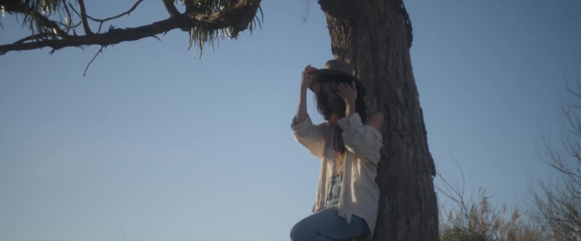 A clip of a lady posing beside a tree