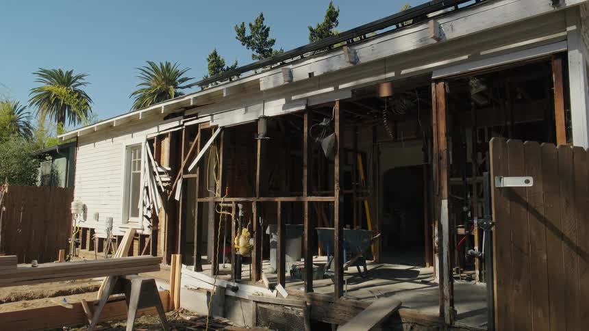 Part of a home undergoing remodeling faces the backyard