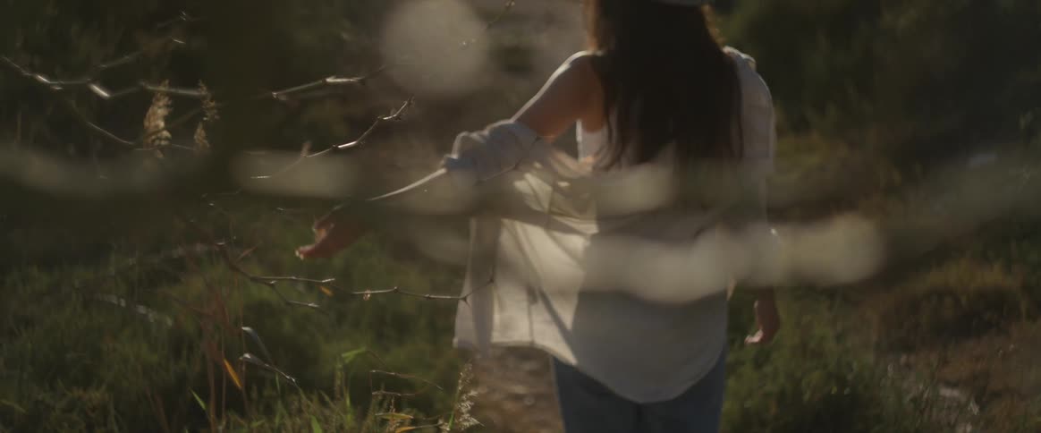 A woman is walking through the grass