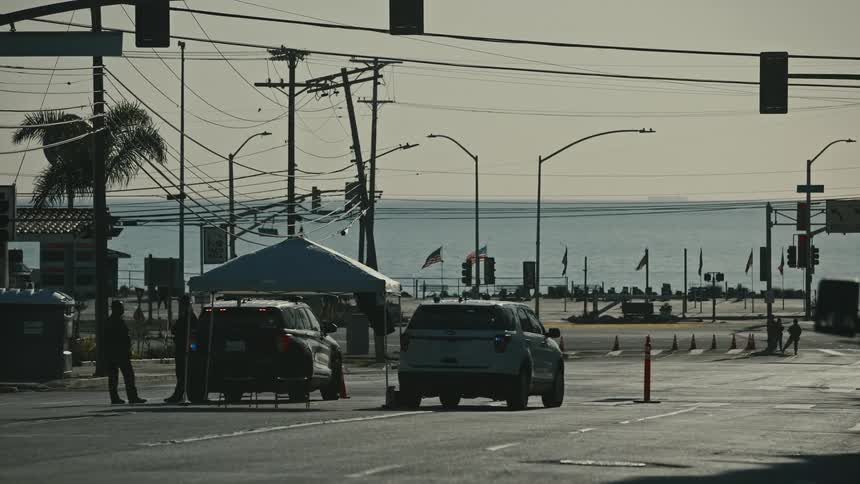 Police are parked in the middle of the street by the shore