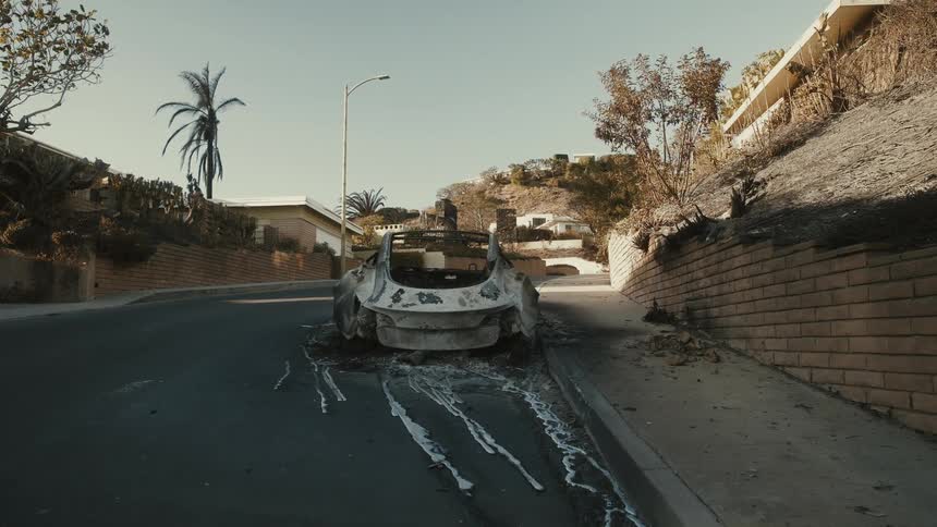 A clip of a ruined car in the street