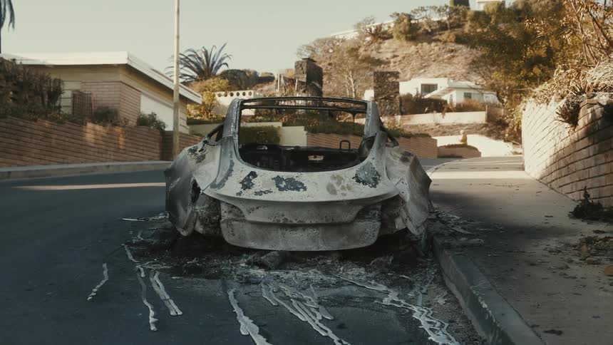 The car is completely burned down on the road