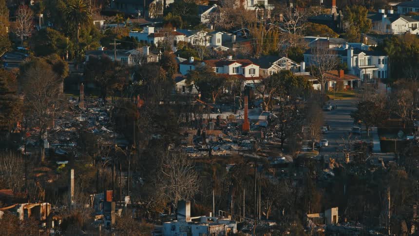 Area devastated by fire with a mixture of intact houses and ruins of burned buildings