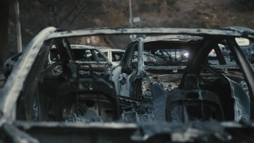 Burnt and destroyed cars their metal frames twisted and skeletal