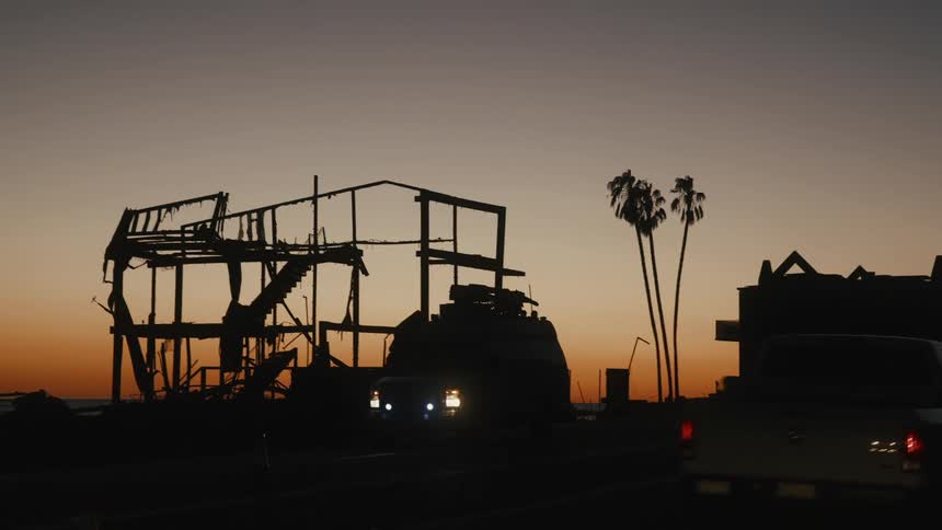 The home is burned down to the frame at sunrise