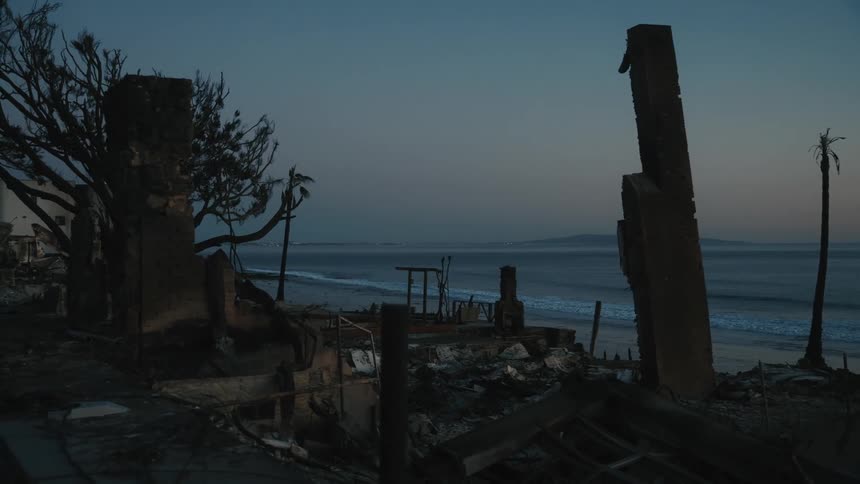 A completely destroyed structure facing the sea some waves