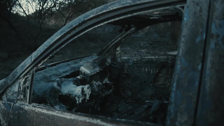 A charred car interior with a burned dashboard