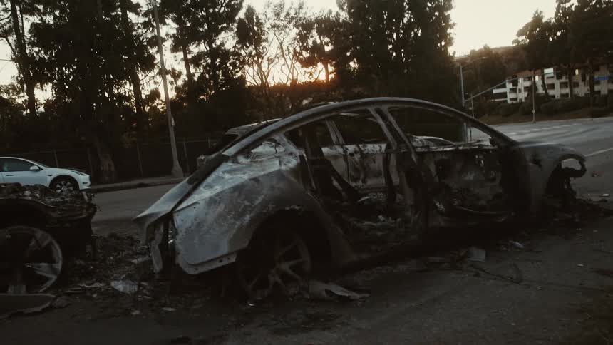 A severely burnt Tesla has melted into the ground while fleeing the Pacific Palisades fire