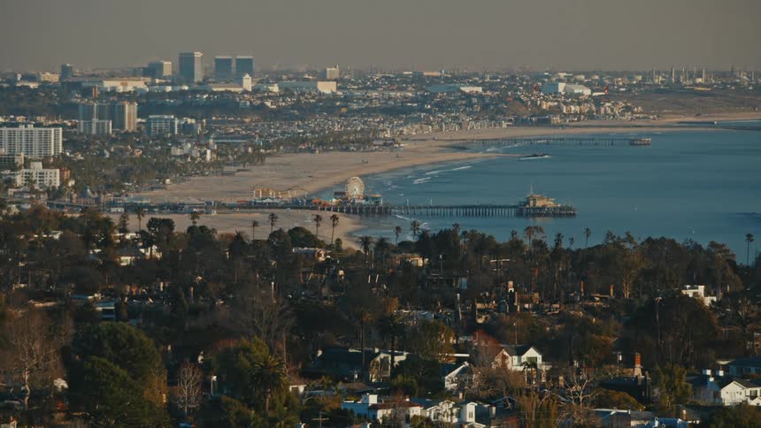 The Santa Monica pier and Venice Beach California with burned homes from the Palisades Fire in the foreground