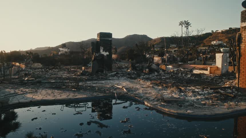 A pond is in the middle of a large area that has debris scattered everywhere from destruction