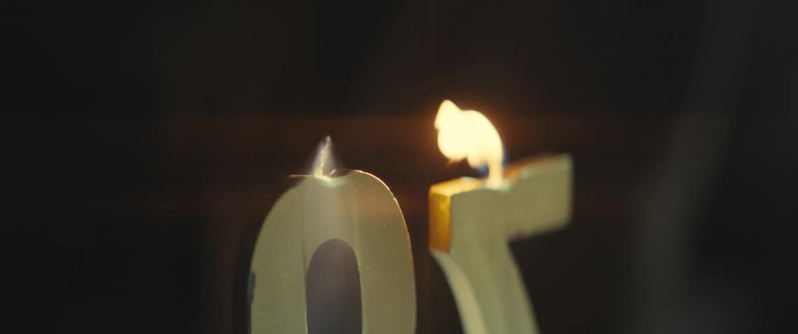 Person blowing out lit birthday candles