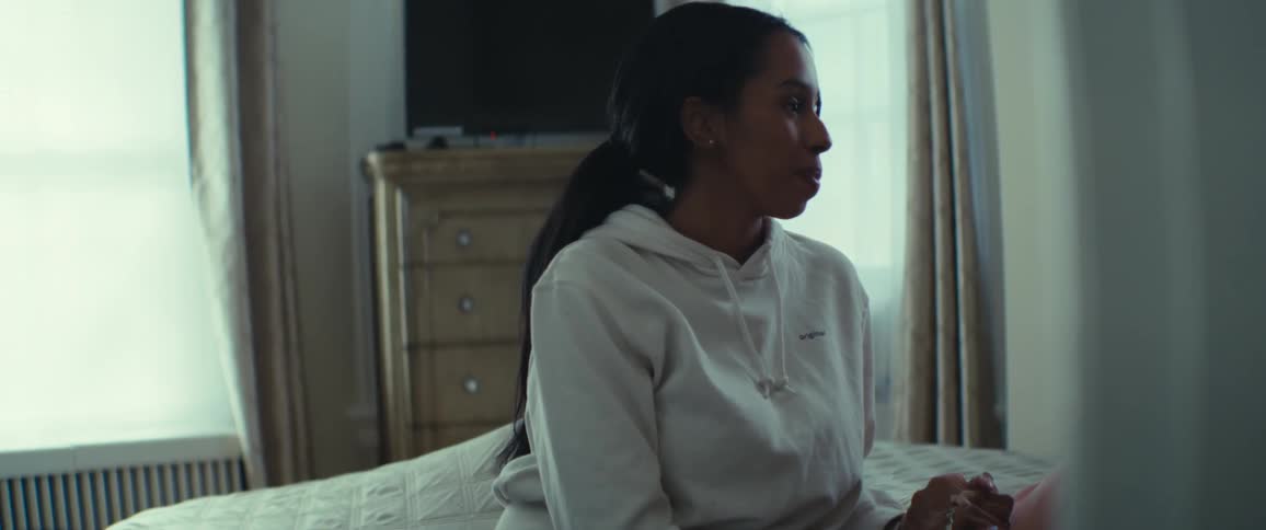 Woman sitting on the bed in a room talking