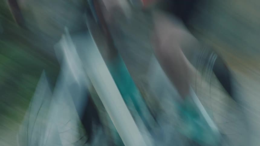 A woman is pedaling fast on a rural road
