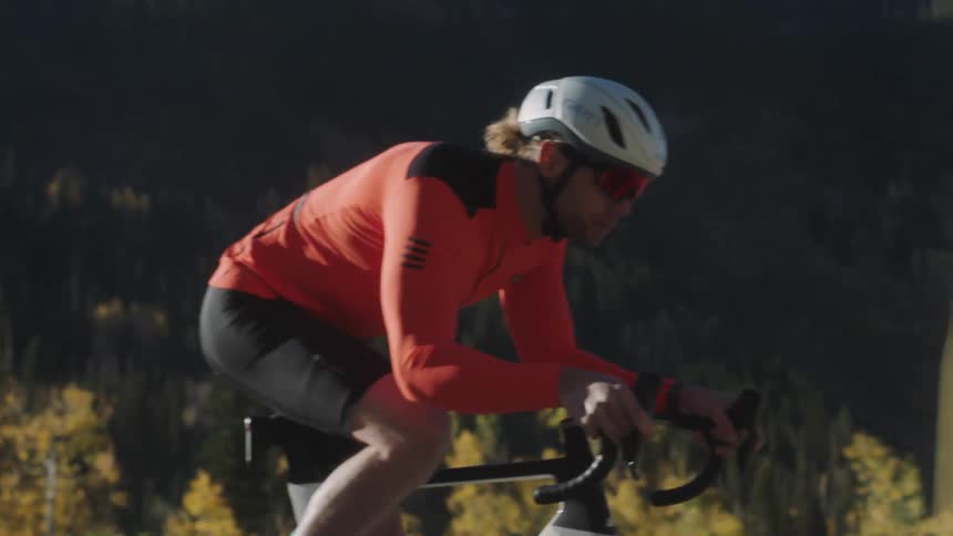 A man is coasting on his bike on a road