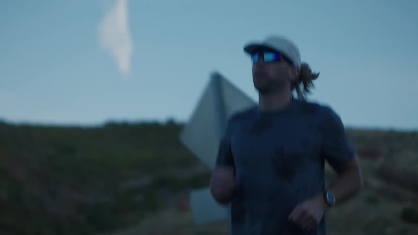 A man is jogging on a rural road in the morning
