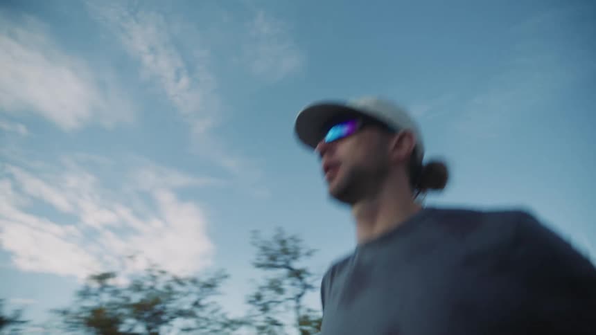 Man in sports glasses and cap running outdoors