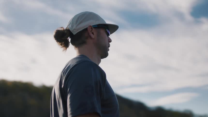 Man in glasses and cap enjoying the view in a mountainous landscape