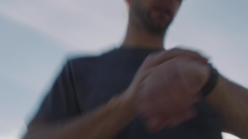 Man in cap setting his wristwatch