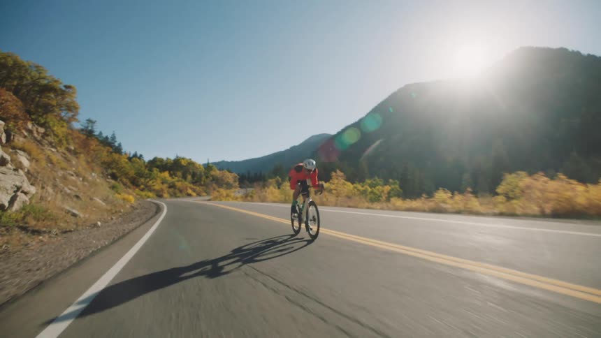 A man speeds down the road on his bicycle