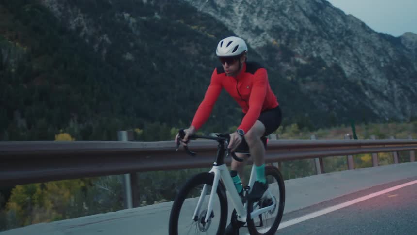 A man struggles as he pedals up a mountain road
