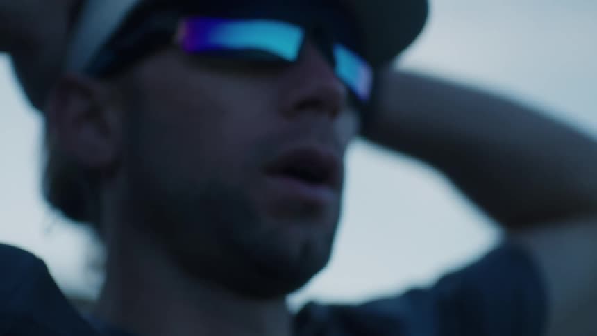 A man is breathing heavy under a cloudy sky