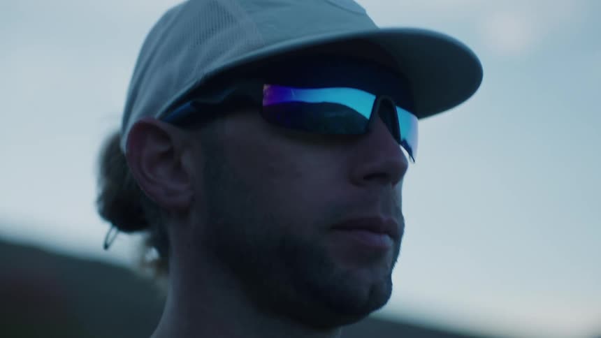Closeup of a runners focused expression with glasses reflecting the sky