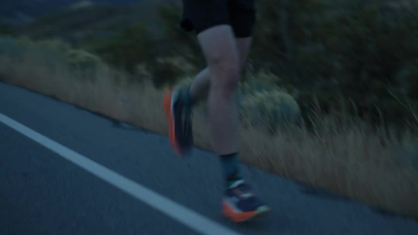 A man runs down the road as the sun rises
