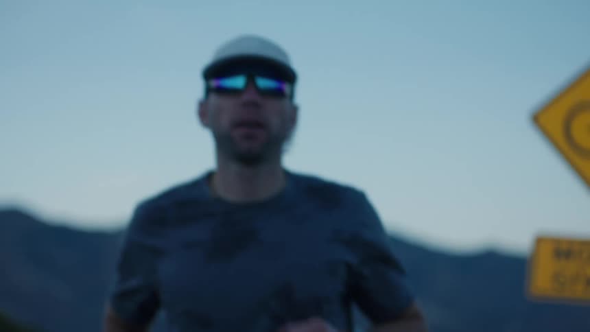 Man in cap and glasses running outdoors