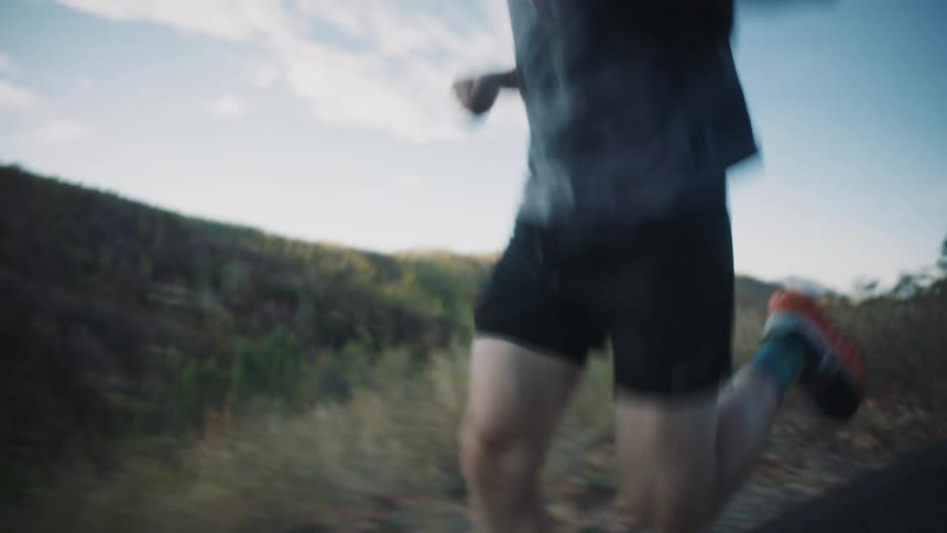 A man is jogging on a road with trees in the background