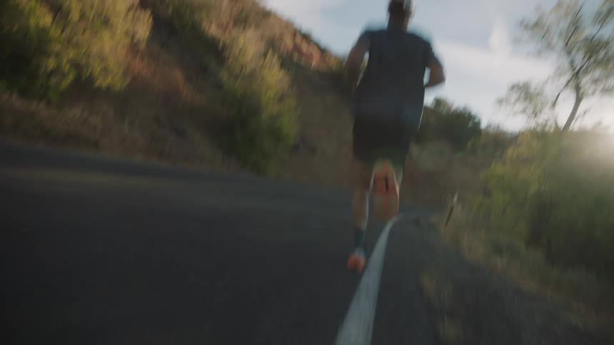 Man running outdoors in an environment surrounded by mountains