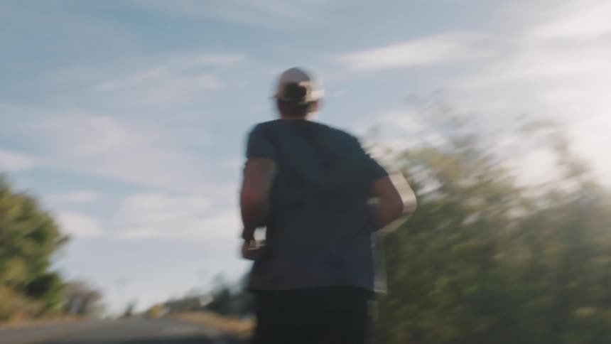 Man in cap running outdoors with green landscape and mountains