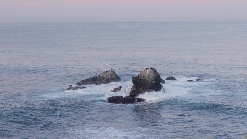 Rocks with cliffs in the middle of the ocean with waves crashing