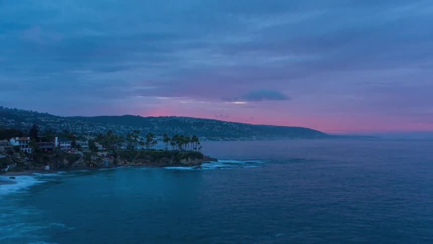 Landscape of a beach with a vast ocean and the sun rising on the horizon