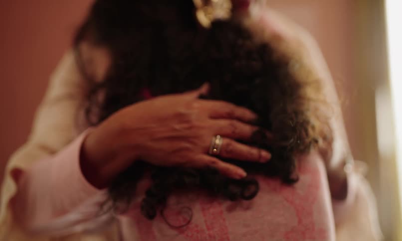 Grandmother lovingly hugging her daughter and patting her on the back