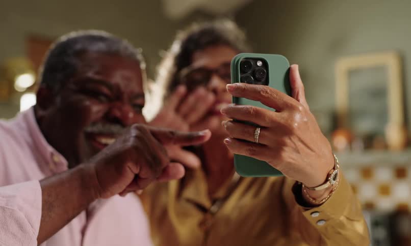 Couple happily talking in front of a smartphone