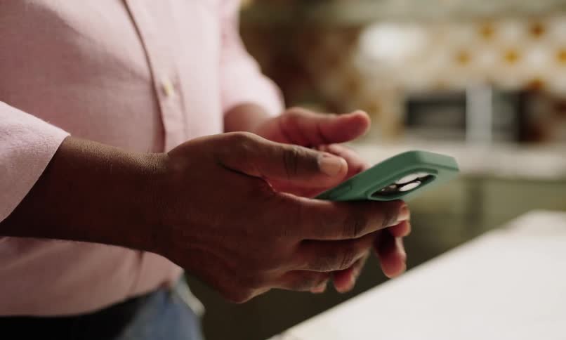 A man is dialing on his cell phone