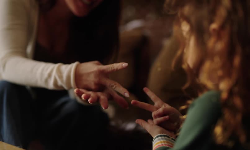 Mother and daughter playing rock paper scissors