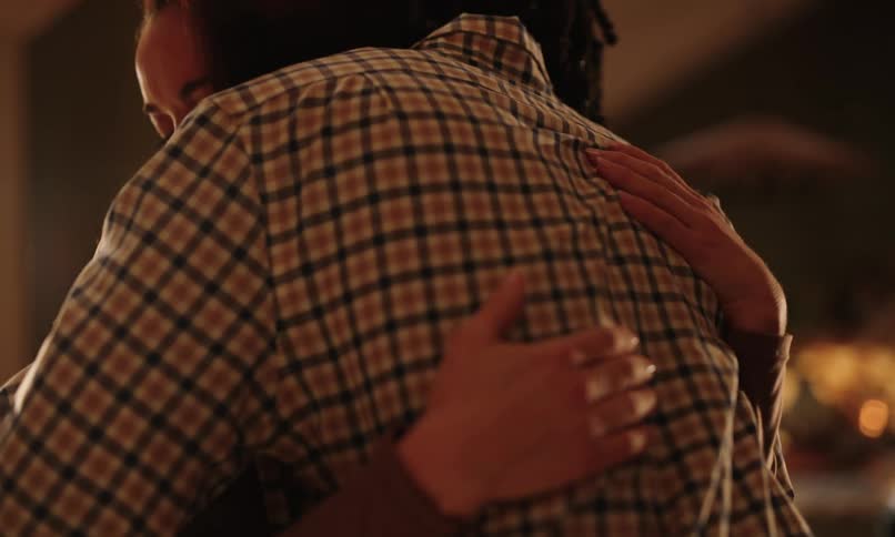 Two people hugging each other affectionately in an indoor space