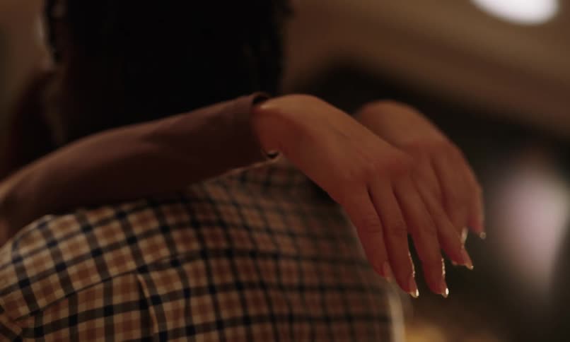 Womans hand on the back of a mans neck as they embrace