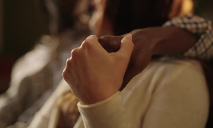 Couple sitting together holding hands in a romantic way