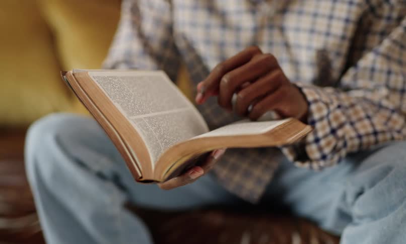 A man is reading and flipping pages in a book