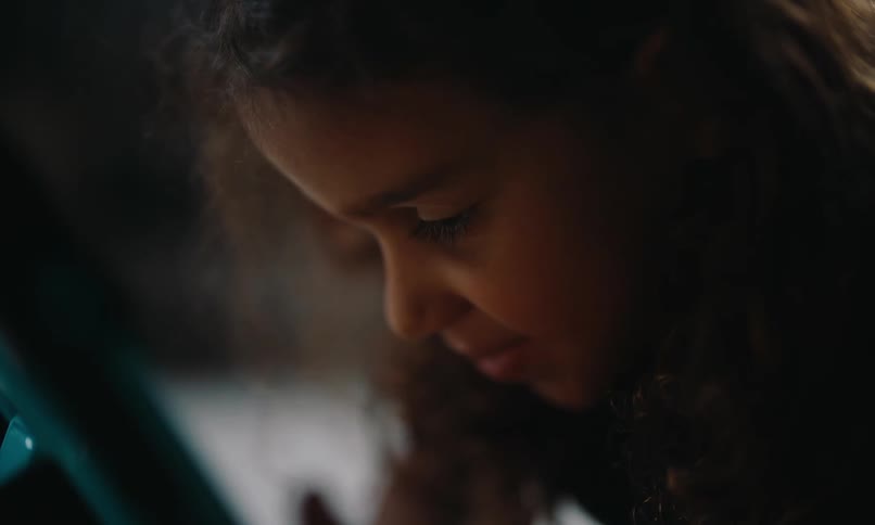 A girl is looking down and examining something