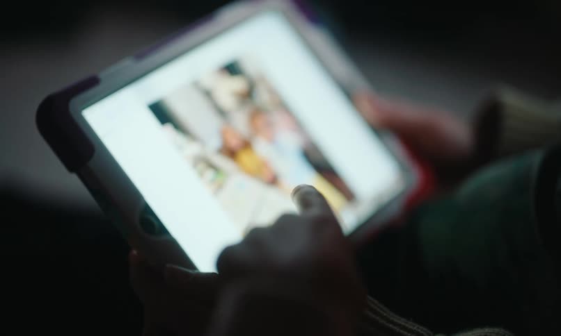 A person is scrolling through photos on a tablet