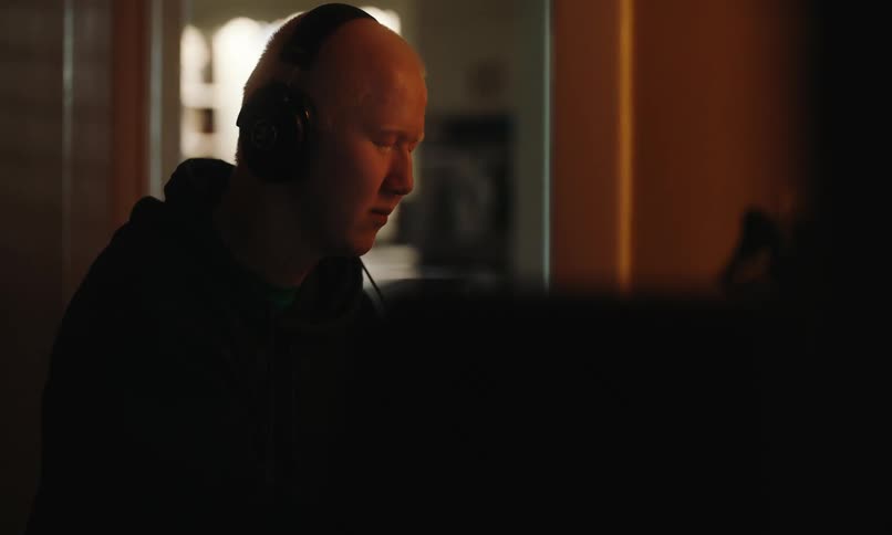Man wearing headphones plays the piano