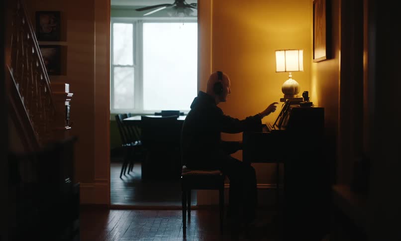 Man sitting playing piano in a room