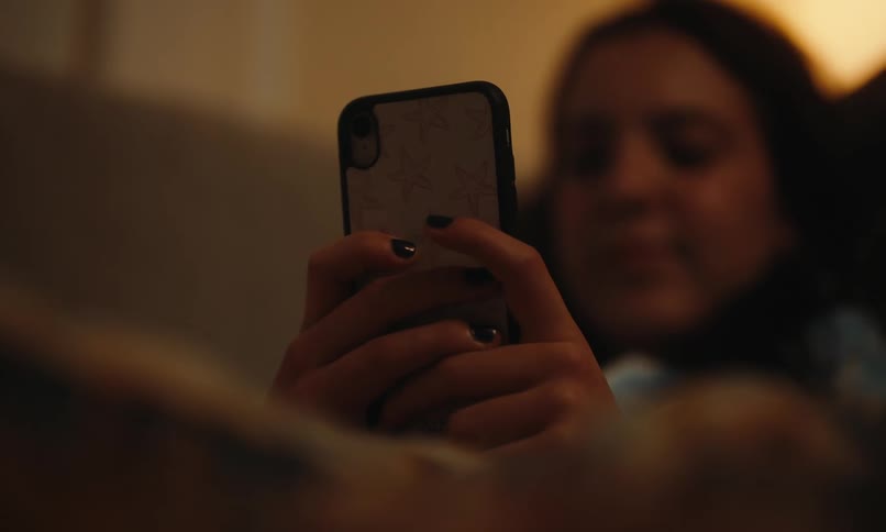 Young woman sitting interacting with a smartphone