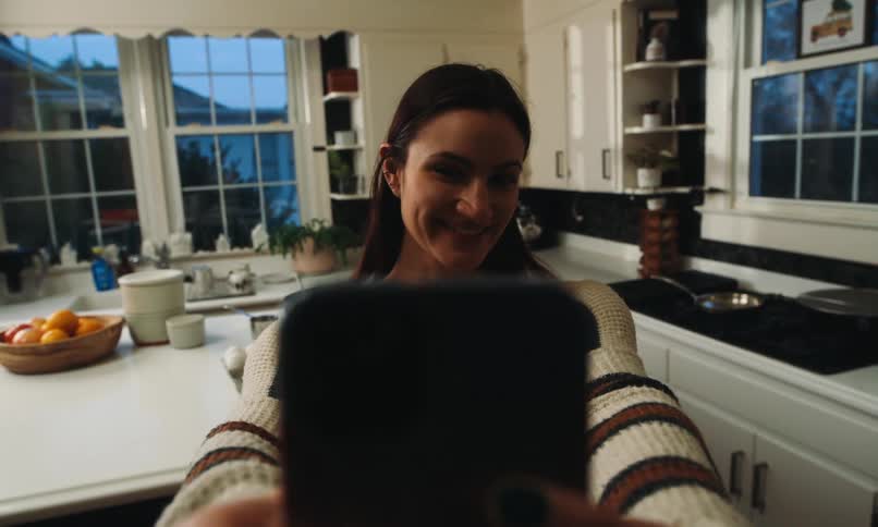 Woman smiling and taking a selfie with her smartphone